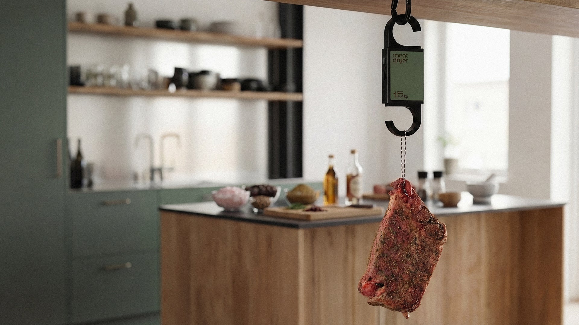 Biltong meat on a hanging Meatdryer meat hook scale in a kitchen setting with olive oil and spices