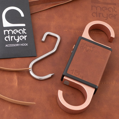 Meatdryer accessory hook on a brown leather surface with Meatdryer Artisan