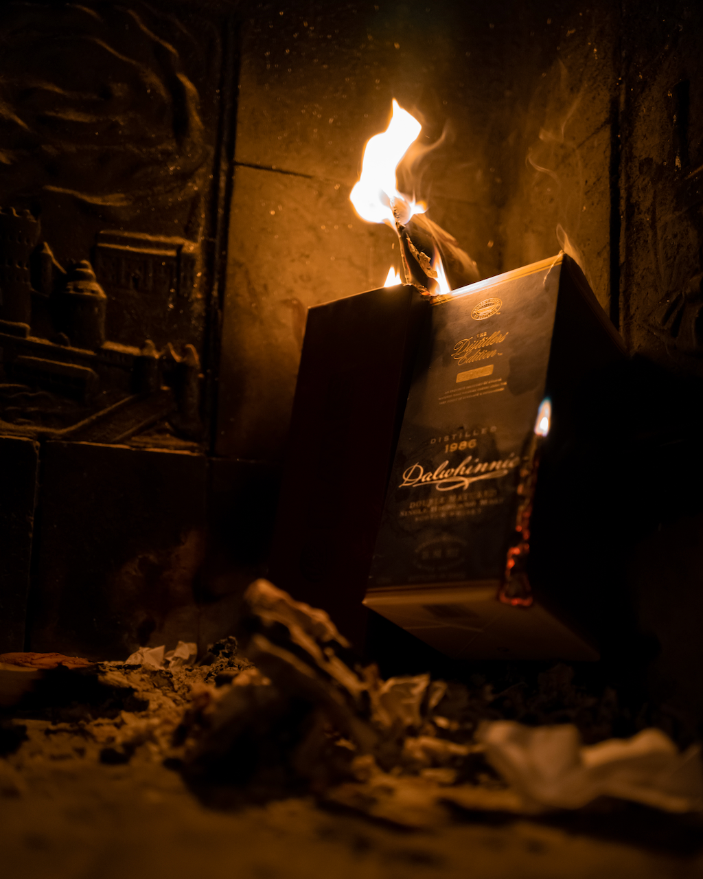 Whisky/ whiskey/ bourbon box on fire with flames and smoke in a dark setting